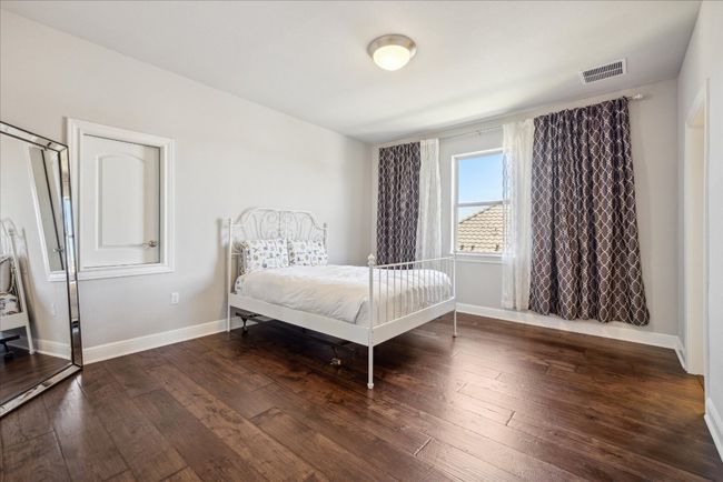Bedroom featuring baseboards, visible vents, and wood-type flooring | Image 28