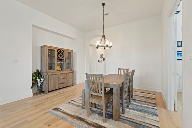 Dining area with a chandelier and light wood-style floors | Image 18