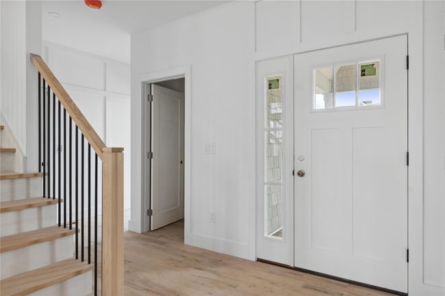 Entrance foyer with light wood-type flooring, baseboards, and stairway | Image 8