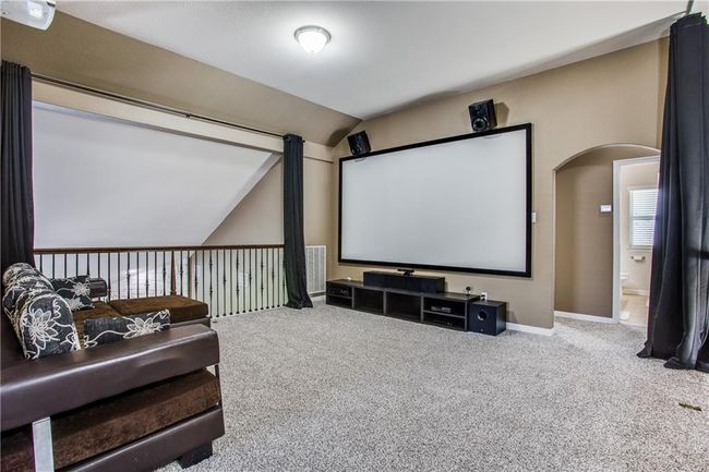 Cinema room featuring vaulted ceiling, carpet flooring, and arched walkways | Image 15
