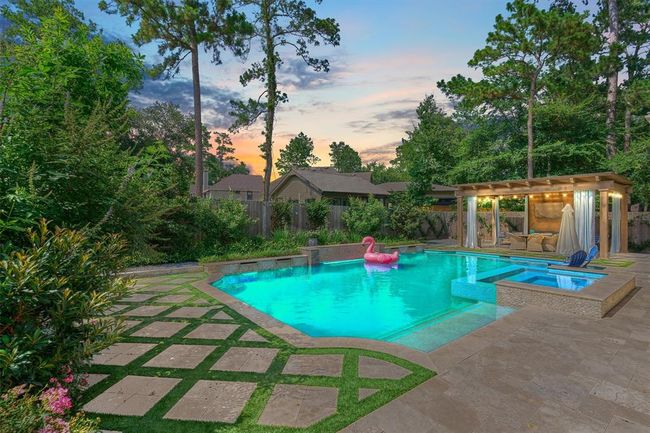 The diamond-style pavers mimic the sweet-smelling jasmine along fence. Lush landscaping and travertine pool deck. | Image 38