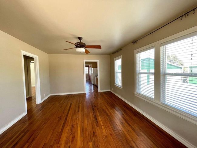 Empty room featuring baseboards, dark wood-style floors, and a ceiling fan | Image 4