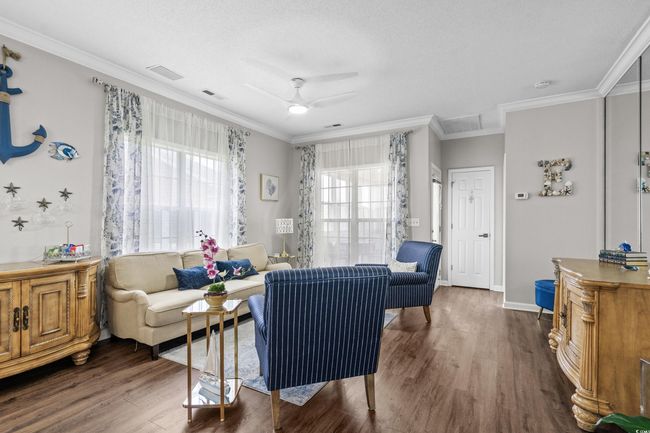 Living area featuring wood finished floors, crown molding, and ceiling fan | Image 8