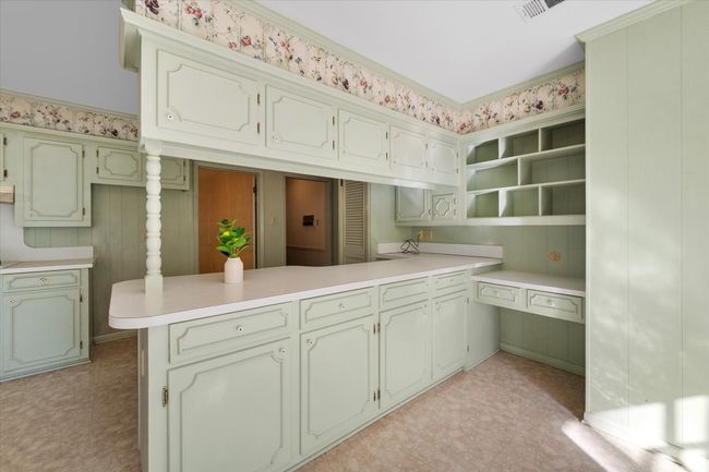 Kitchen featuring open shelves, light countertops, a peninsula, and light floors | Image 16