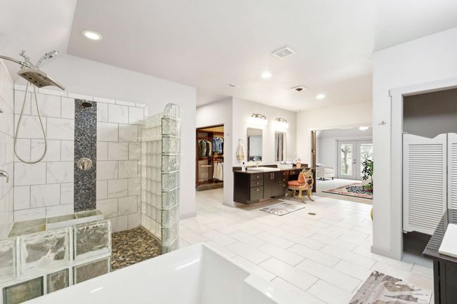 Bathroom with a tile shower, tile patterned floors, french doors, and vanity | Image 25