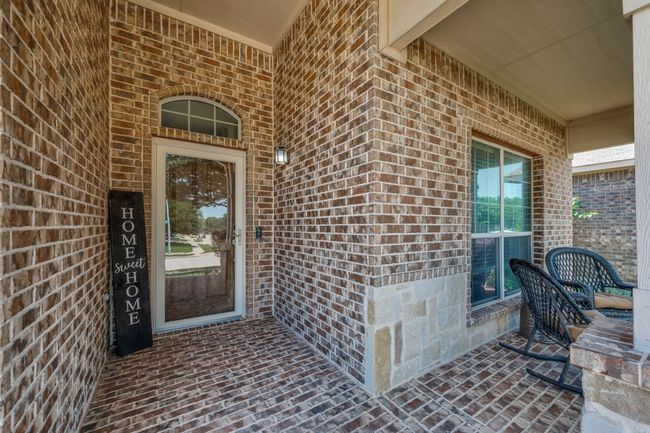 Welcoming entry with cozy brick covered porch | Image 6