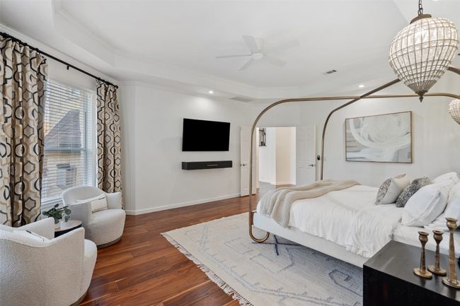 Bedroom featuring dark wood-style floors, baseboards, arched walkways, ornamental molding, and recessed lighting | Image 13