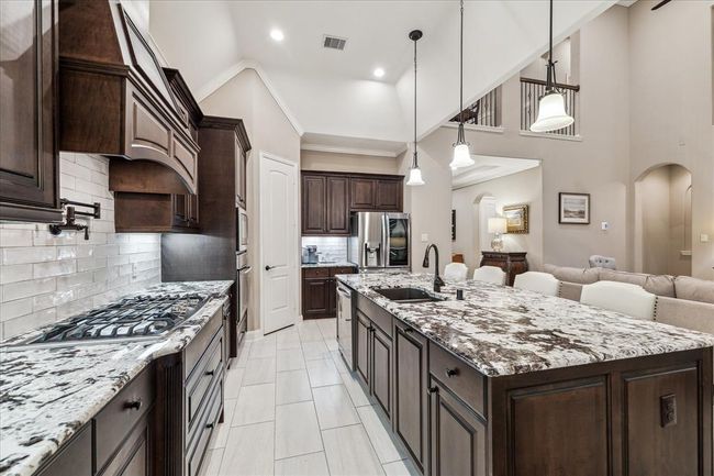 Undercabinet lighting, gas cooktop, the pot filler, the custom tiled backsplash and a NEW dishwasher in 2025 highlight the kitchen. | Image 11