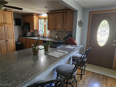 Kitchen with dark hardwood / wood-style flooring, sink, a wealth of natural light, and ceiling fan | Image 3