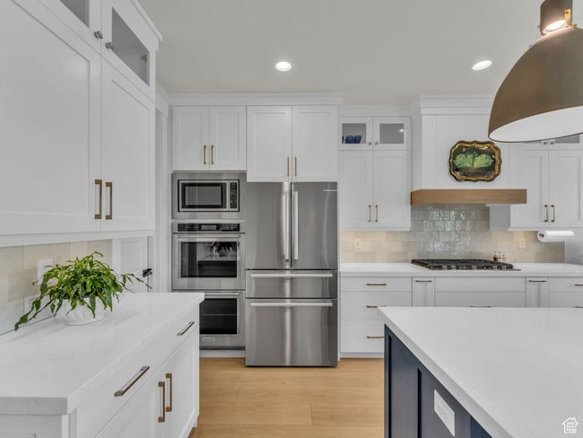 Kitchen with appliances with stainless steel finishes, light countertops, white cabinets, and recessed lighting | Image 13