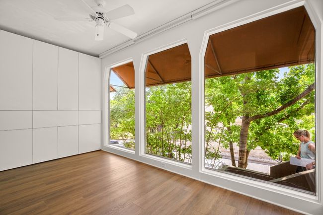 Floor to ceiling windows in the office, plus floor to ceiling custom built in cabinetry for storage. | Image 11