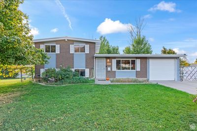 Split level home featuring a front yard and a garage | Image 1