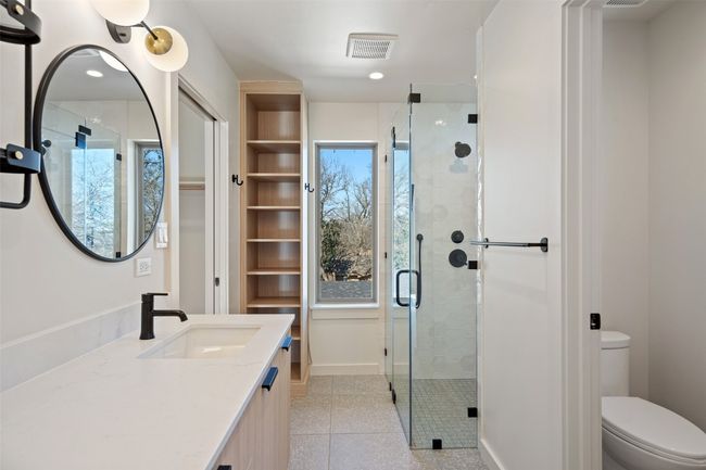 Full bathroom featuring toilet, a stall shower, baseboards, and visible vents | Image 16