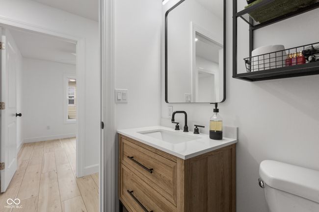 half bath featuring toilet, vanity, wood finished floors, and baseboards | Image 41