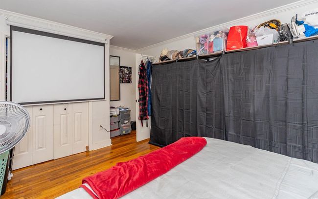 Bedroom featuring ornamental molding, wood finished floors, and a closet | Image 8
