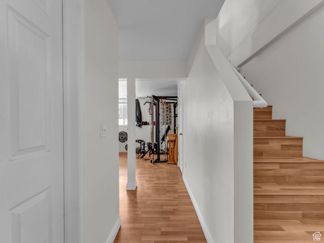 Hallway with light wood finished floors, baseboards, and stairway | Image 21