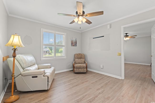 Living area with a ceiling fan, light wood-type flooring, and crown molding | Image 33