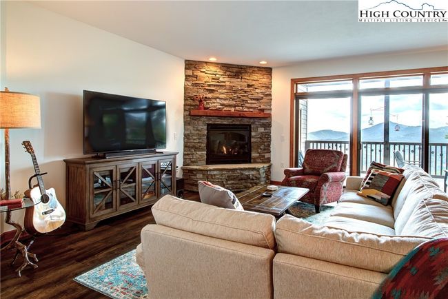 Imagine cuddling up in front of the stacked stone gas log fireplace and watching the snow fly out the huge sliding glass doors. | Image 12