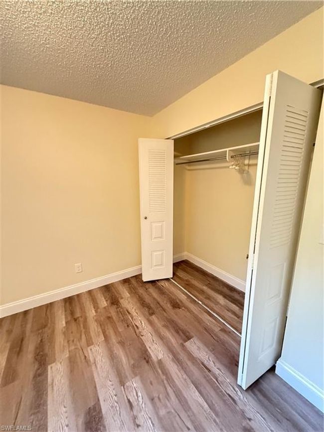 Unfurnished bedroom featuring baseboards, wood finished floors, and a closet | Image 12