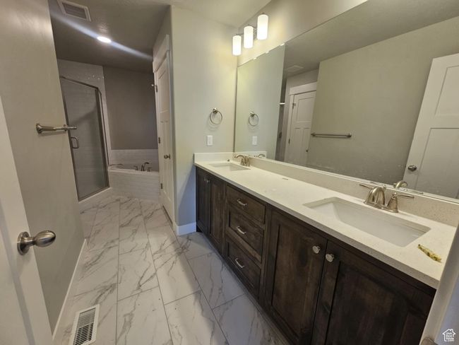 Bathroom with marble finish floors, baseboards, a garden tub, double vanity, and a shower stall | Image 5
