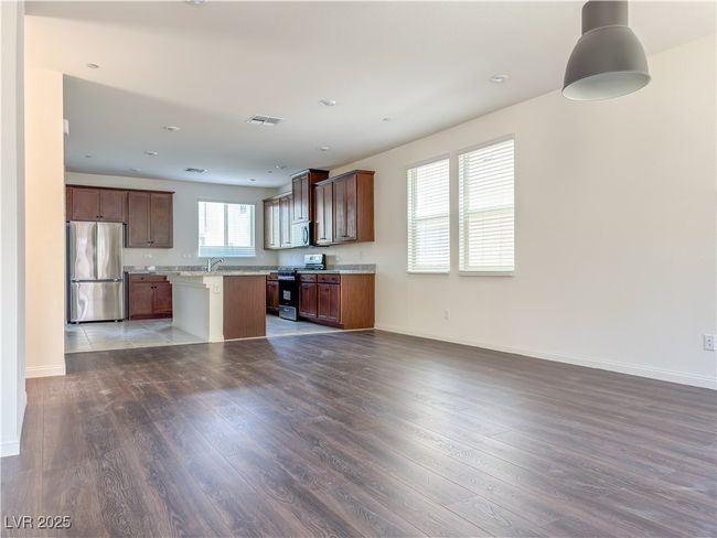 Kitchen with freestanding refrigerator, open floor plan, gas range, wood finished floors, and recessed lighting | Image 9