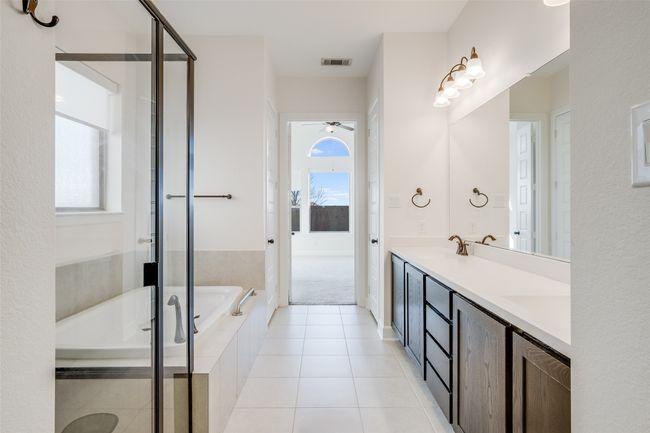 Full bathroom featuring a bath, plenty of natural light, double vanity, and a stall shower | Image 20