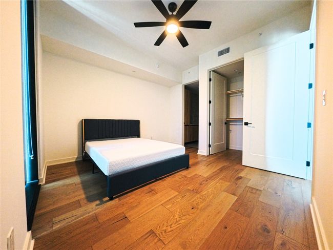 Bedroom with wood finished floors and ceiling fan | Image 6