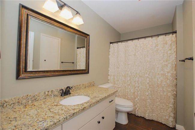 Full guest bath with wood-like tile floors | Image 16