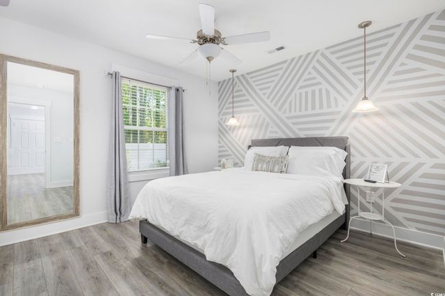 Bedroom featuring ceiling fan, baseboards, wood finished floors, and visible vents | Image 28