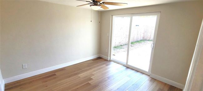 rear bedroom with door which opens on to a deck and the back yard. | Image 18
