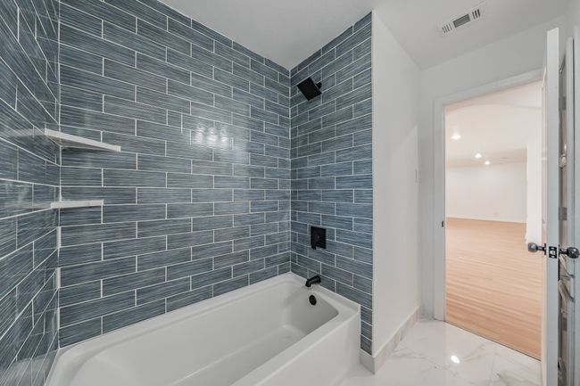 Bathroom featuring marble finish floors, baseboards, and washtub / shower combination | Image 5