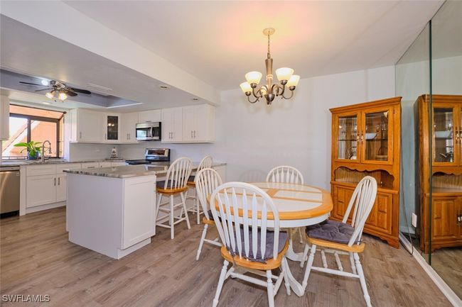 Dining space with a chandelier, light wood finished floors, and a ceiling fan | Image 12