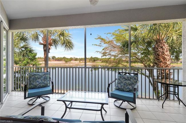 Furnished Screened lanai with access to the primary bedroom and the dinnett area bedroom, lake view, fan and tile flooring | Image 4