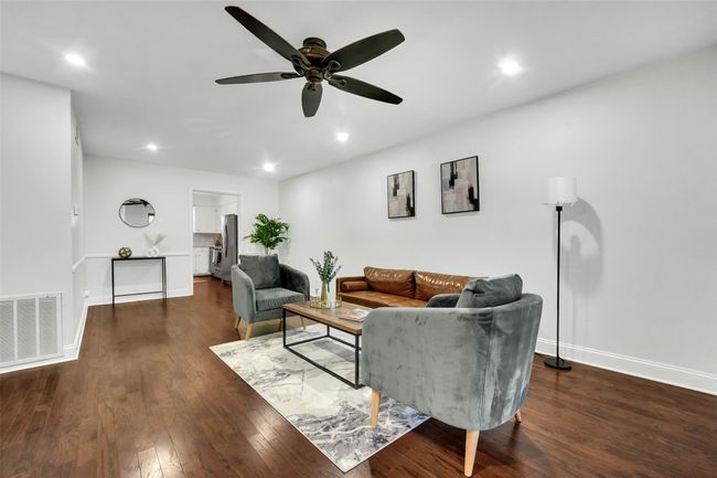 Living room with wood finished floors, a ceiling fan, and recessed lighting | Image 7