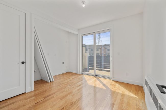 Spare room featuring radiator heating unit, light wood finished floors, and baseboards | Image 20