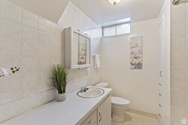 Bathroom with vanity, tile patterned flooring, and tile walls | Image 27