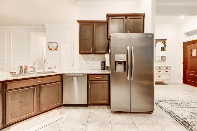 Open concept kitchen with dark wood cabinets, farmhouse sink, and granite countertops | Image 9