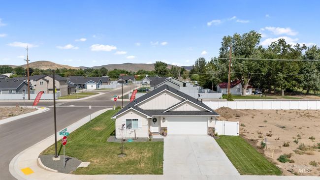 View of front of house featuring board and batten siding, a mountain view, concrete driveway, a residential view, and a garage | Image 27