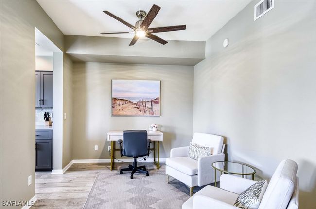 Additional sitting area with a desk, ceiling fan. | Image 10