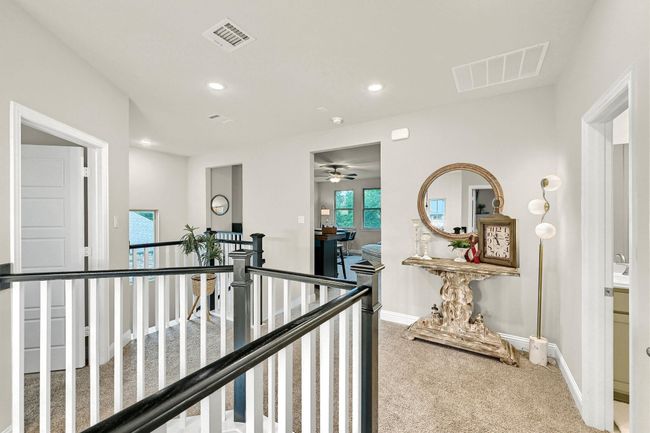 Hall with baseboards, an upstairs landing, visible vents, and carpet | Image 25