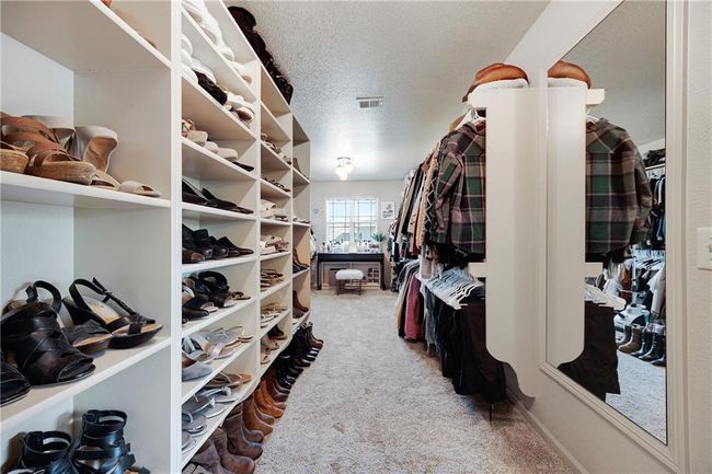 Huge primary walk in closet with carpet, shelving and hanging space. | Image 32