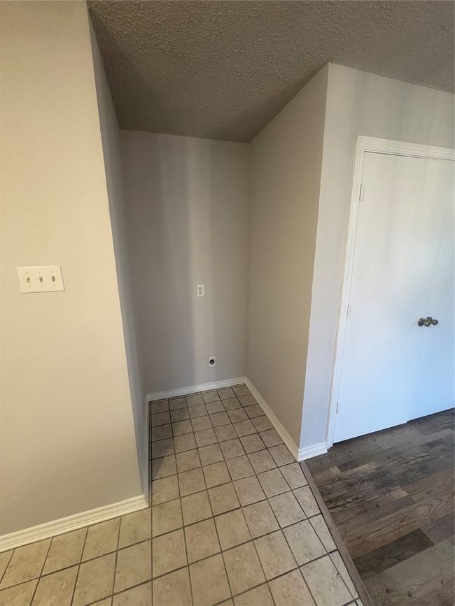 Spare room featuring light tile patterned flooring, baseboards, and a textured ceiling | Image 8