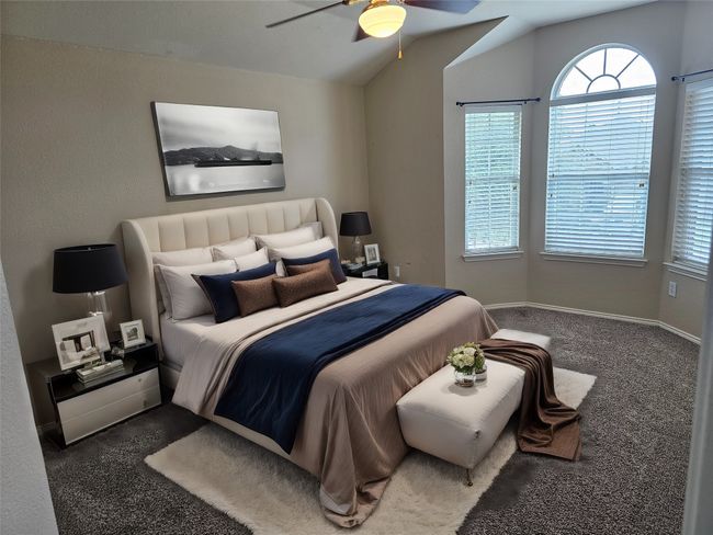 Carpeted bedroom with vaulted ceiling and a ceiling fan | Image 23