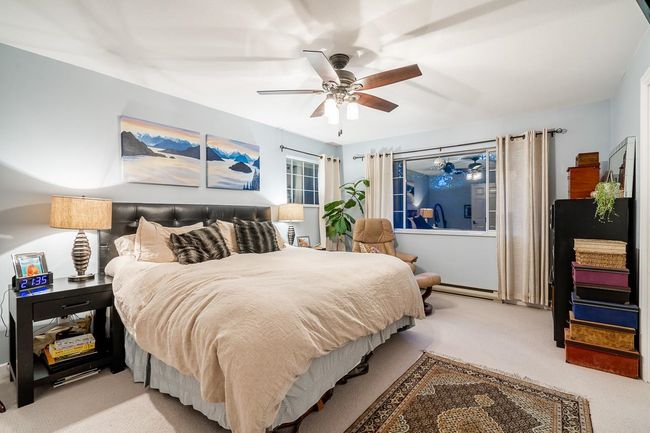 Bedroom with carpet flooring, baseboard heating, and a ceiling fan | Image 13