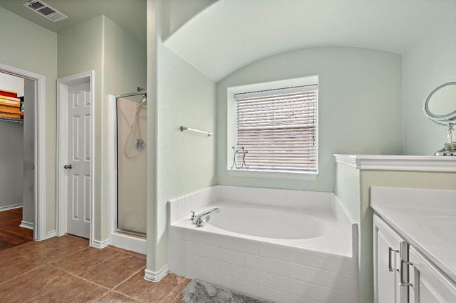 Bathroom with a bath, a stall shower, vanity, a spacious closet, and tile patterned flooring | Image 19