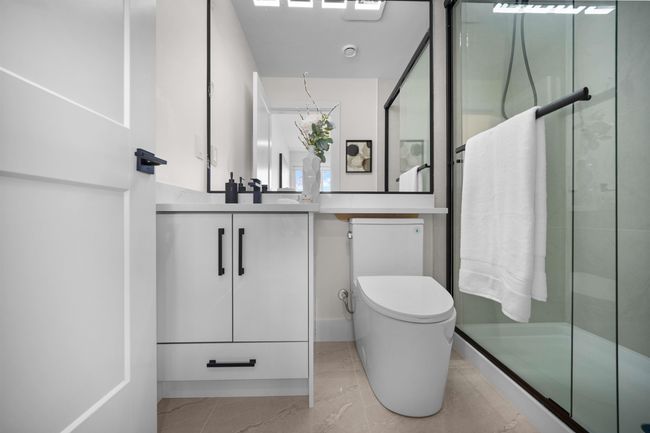 Bathroom with vanity, a shower with door, and tile patterned flooring | Image 14