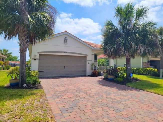 Ranch-style house with a tiled roof, a garage, a front yard, stucco siding, and decorative driveway | Image 5