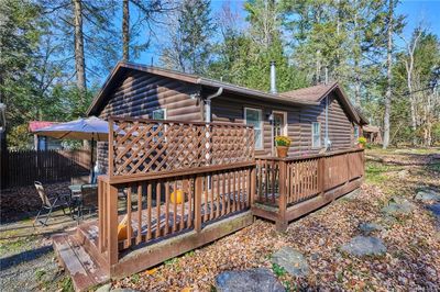 Rear view of property with a wooden deck | Image 1