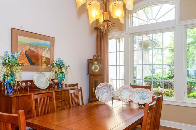 Formal dining area with arched windows. | Image 13