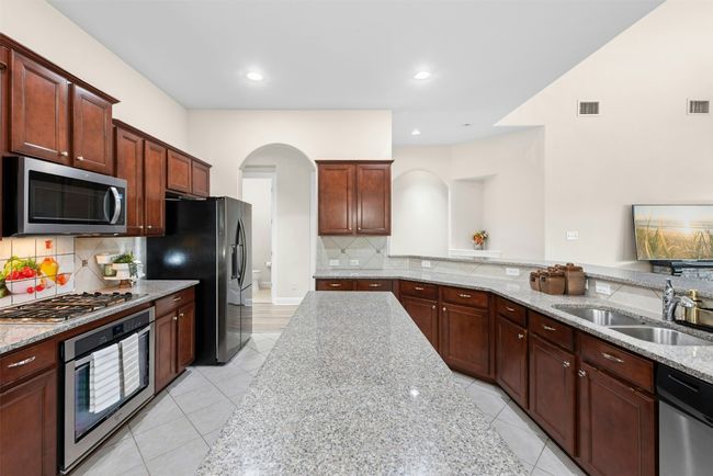 Gourmet kitchen with stainless steel appliances and large center island. Lots of cabinets for storage and counter space for meal prep. | Image 5